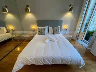 a large white bed in a room with windows at Formosa Apartments in Porto