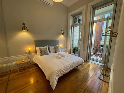 a bedroom with a large bed and a large window at Formosa Apartments in Porto