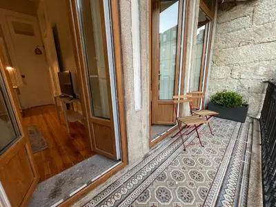a chair sitting on the porch of a house at Formosa Apartments in Porto
