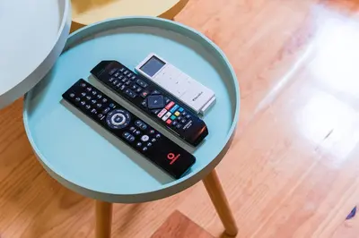 a table with two remotes and a cell phone on it at GuestReady - Green Bay Garden in Porto