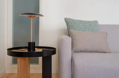 a black table next to a couch with a lamp at GuestReady - Catorze de Outubro Houses 423 in Vila Nova de Gaia