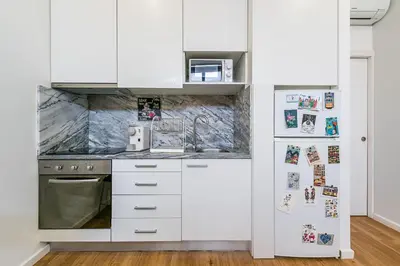 a kitchen with white cabinets and a refrigerator at GuestReady - Bella's Downtown Apartment in Porto