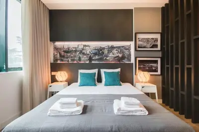 a bedroom with a large bed with blue pillows at 447 Galé Apartment wifi, parking in Porto