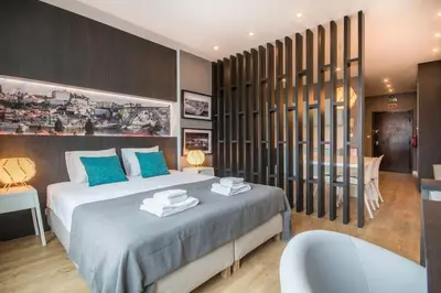 a bedroom with a bed with blue pillows and a tub at 447 Galé Apartment wifi, parking in Porto