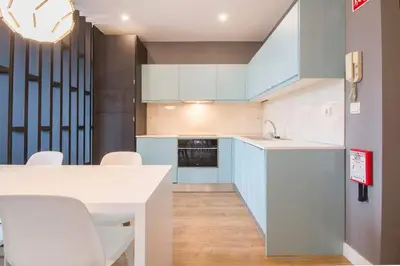a kitchen with white cabinets and a table and chairs at 447 Galé Apartment wifi, parking in Porto