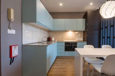 a kitchen with blue cabinets and a table with chairs at 446 Galé Modern Apartment elevator,parking in Porto