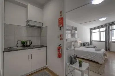 a kitchen and a bedroom with a bed in a room at Travel & Live Aliados Apartment in Porto