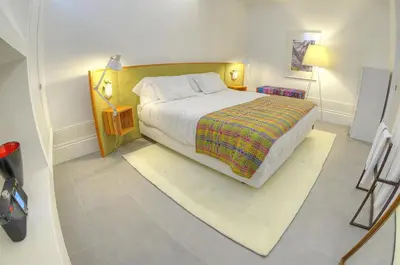 a bedroom with a large bed and a tiled floor at Three Houses & Bedrooms in Porto