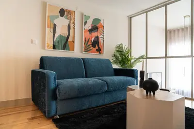 a blue couch in a living room with a table at Shiny Porto in Porto