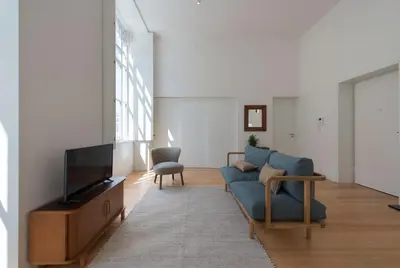 a living room with a blue couch and a tv at Tripas-Coração, Santa Catarina in Porto