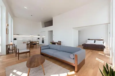 a living room with a blue couch and a bedroom at Tripas-Coração, Santa Catarina in Porto