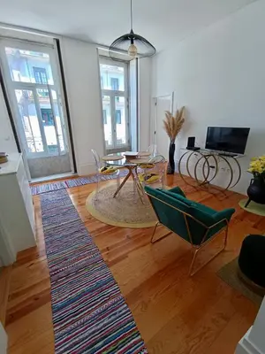 a living room with a table and chairs at Appartement Pont Luiz in Porto