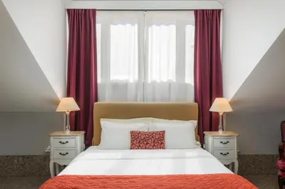 a bedroom with a large bed with red curtains at Carpe Diem Apartments in Porto