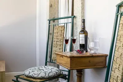 a bottle of wine on a table with wine glasses at Carpe Diem Apartments in Porto