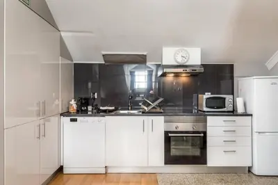 a kitchen with white cabinets and a white refrigerator at Carpe Diem Apartments in Porto