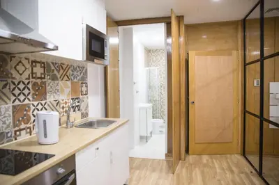 a kitchen with a sink and a door to a bathroom at Estúdio Corujeira in Porto