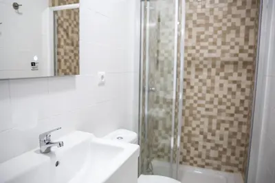 a bathroom with a shower and a sink and a toilet at Estúdio Corujeira in Porto