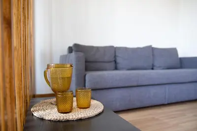 a table with two yellow vases and a couch at Estúdio Corujeira in Porto