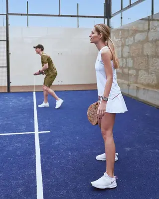 a man and a woman standing on a tennis court at BFRESH Hotel - Padel, Pool & Fitness - Adults Only in Porto