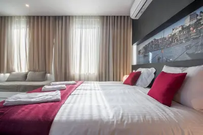 a bedroom with a large bed with red pillows at 607 Galé Apartamento Wi-Fi, estacionamento in Porto