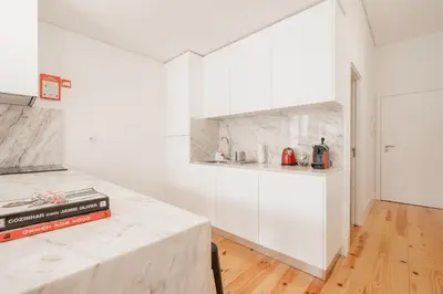 a kitchen with white walls and a marble counter top at Oporto Shine in Porto