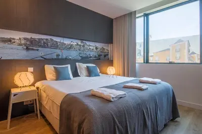 a bedroom with a large bed with a large window at 408 Galé Center Apartamento Wi-Fi, estacionamento in Porto