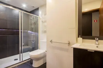 a bathroom with a toilet and a sink and a shower at 408 Galé Center Apartamento Wi-Fi, estacionamento in Porto