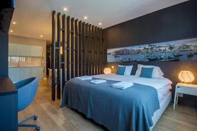 a bedroom with a large bed with blue sheets at 408 Galé Center Apartamento Wi-Fi, estacionamento in Porto