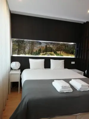 a bedroom with a large bed with a large window at 404 Galé Center Apartment wifi, parking in Porto