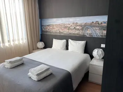 a bedroom with a bed with two towels on it at 411 Galé Center Apartamento Wi-Fi, estacionamento in Porto