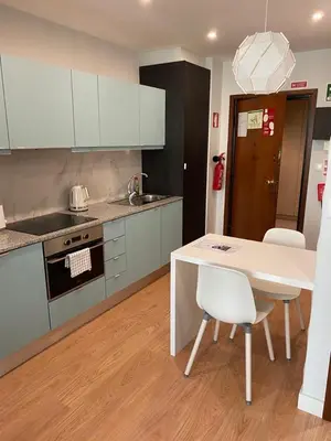 a kitchen with a white table and chairs and a stove at 411 Galé Center Apartamento Wi-Fi, estacionamento in Porto