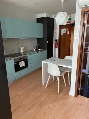 a kitchen with blue cabinets and a white table and chairs at 411 Galé Center Apartamento Wi-Fi, estacionamento in Porto