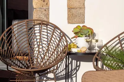 two wicker chairs and a table with food on it at Luxurious Townhome with River View by LovelyStay in Porto
