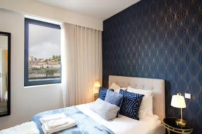 a bedroom with a bed with a blue accent wall at Luxurious Townhome with River View by LovelyStay in Porto