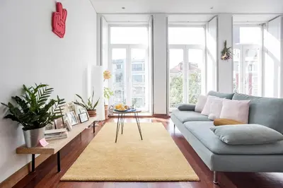 a living room with a blue couch and a rug at Bonjardim Studio w/ Balcony by LovelyStay in Porto