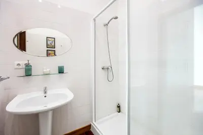 a white bathroom with a sink and a shower at Bonjardim Studio w/ Balcony by LovelyStay in Porto