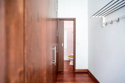 a bathroom with a toilet and a wooden door at Bonjardim Studio w/ Balcony by LovelyStay in Porto