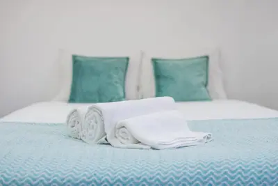 a pile of towels sitting on top of a bed at Papa 1T · Papa Studio Central Garden View in Porto
