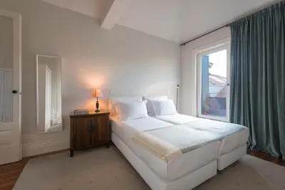 a white bedroom with a large bed and a window at Habitat137 in Porto