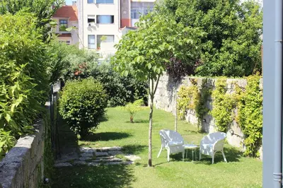 a garden with two chairs and a table and a tree at Habitat137 in Porto