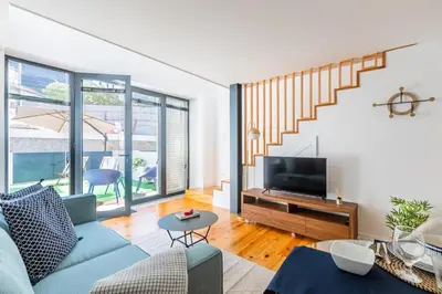 a living room with a yellow couch and a television at Heroismo Duplex Terrace in Porto
