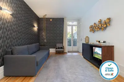 a living room with a blue couch and a tv at Host Wise - Homely Noble Flats - Garden & Jacuzzi in Porto