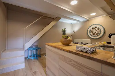 a kitchen with a staircase and a counter with a table at Host Wise - Homely Noble Flats - Garden & Jacuzzi in Porto