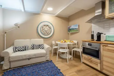 a living room with a couch and a table in a kitchen at Host Wise - Homely Noble Flats - Garden & Jacuzzi in Porto