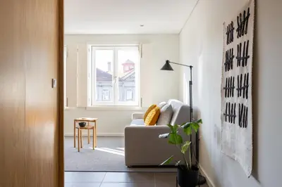 a living room with a couch and a window at Box Market Square Apartment in Porto