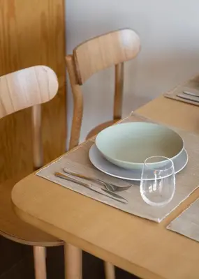 a wooden table with a plate and a glass on it at Box Market Square Apartment in Porto