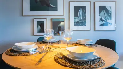 a wooden table with plates and bowls and wine glasses at Stylish Studio w/ AC & Balcony by LovelyStay in Porto