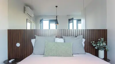 a bedroom with a bed with a wooden headboard at Stylish Studio w/ AC & Balcony by LovelyStay in Porto