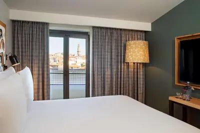 a hotel room with a large bed and a window at Se Catedral Hotel Porto, Tapestry Collection By Hilton in Porto