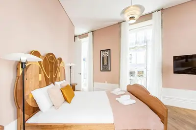 a bedroom with a white bed with a wooden headboard at Artistic 2BR Flat Downtown w/ AC by LovelyStay in Porto